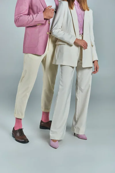 Cropped view of couple in elegant and stylish business attire standing on grey, formal wear — Stock Photo