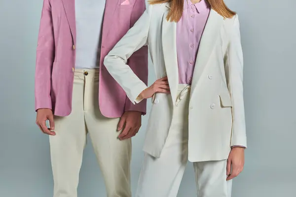 Donna ritagliata di donna con mano sul fianco vicino all'uomo in elegante blazer lilla su grigio, abbigliamento formale alla moda — Foto stock