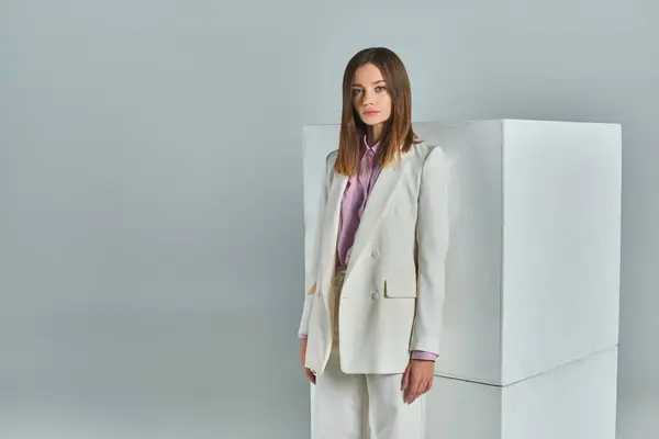 Mode minimaliste, jeune femme en tenue formelle élégante regardant la caméra près de cubes blancs sur gris — Photo de stock