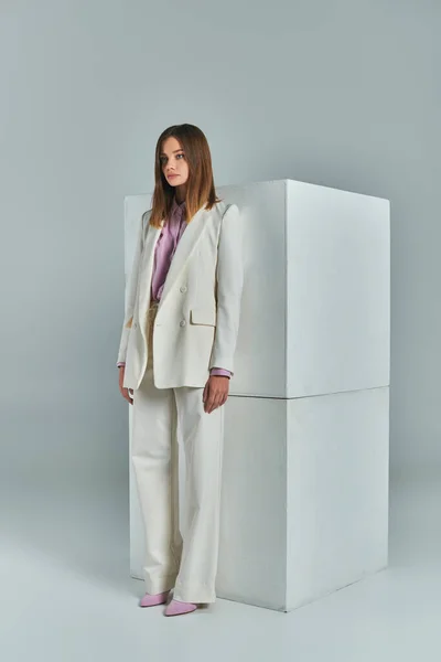 Trajes de negócios na moda, mulher moderna em terno elegante branco em pé perto de cubos em cinza, comprimento total — Fotografia de Stock