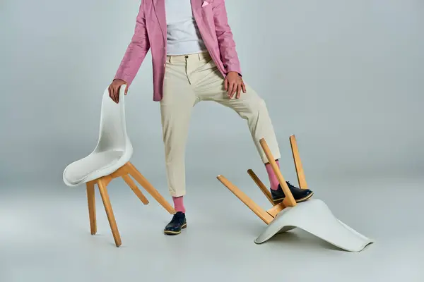 Vista cortada do homem em blazer lilás e calças brancas posando com poltronas em cinza, moda de negócios — Fotografia de Stock