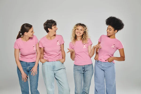 Brustkrebs Bewusstsein, glückliche interrassische Frauen mit rosa Bändern auf grau, Vielfalt, konzeptuelle — Stockfoto