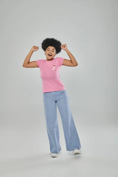Sensibilisation au cancer du sein, concept sans cancer, joie, femme afro-américaine avec ruban rose sur gris — Photo de stock