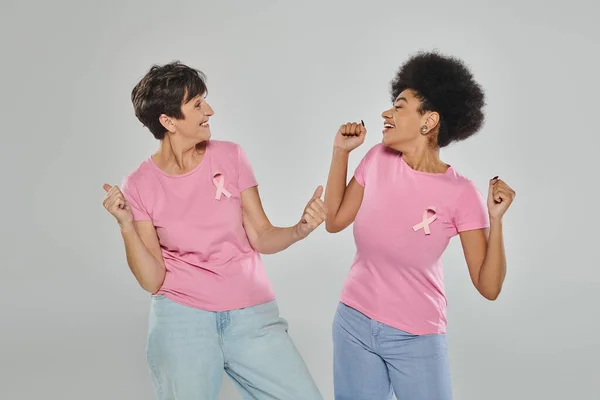 Обізнаність про рак молочної залози, щасливі мультикультурні жінки позують на сірому тлі, підтримка, без раку — стокове фото