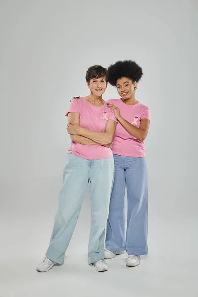 Consapevolezza del cancro al seno, allegre donne multiculturali sorridenti su sfondo grigio, sostegno, senza cancro — Foto stock