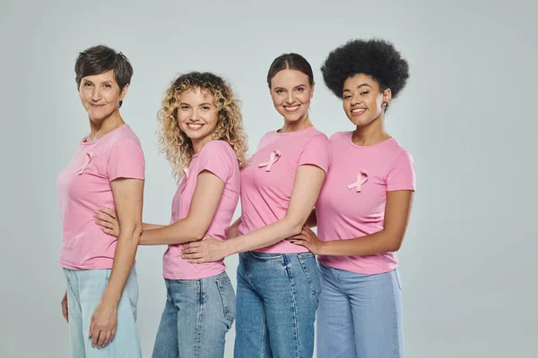 Interracial women different age standing on grey backdrop, support, breast cancer awareness, support — Stock Photo