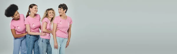 Mulheres multiculturais idade diferente sorrindo em pano de fundo cinza, apoio, consciência do câncer de mama, bandeira — Fotografia de Stock