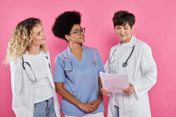 Generations, happy medical colleagues, female oncologists, smile, breast cancer awareness concept — Stock Photo
