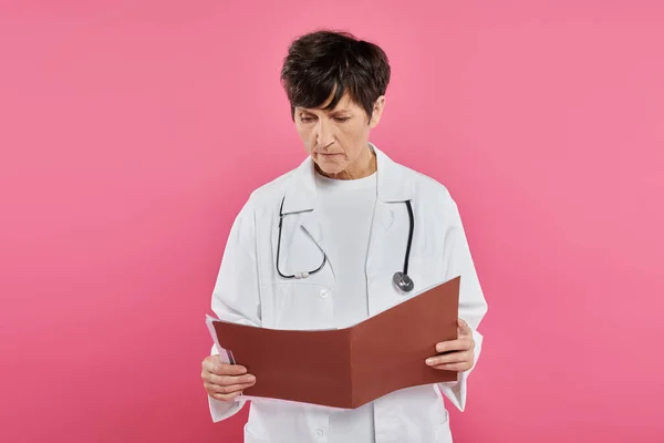 Onkologin mittleren Alters, Ärztin betrachtet Folder, Brustkrebs-Aufklärungskonzept, Diagnose — Stockfoto