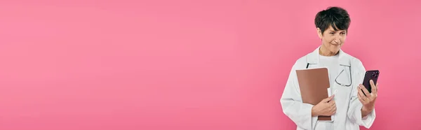 Oncologo maturo, cartella clinica femminile, usando smartphone, consapevolezza del cancro al seno, banner — Foto stock