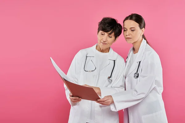 Oncologi femminili, medici che guardano cartelle cliniche, cartelle cliniche, sensibilizzazione sul cancro al seno, campagna — Foto stock