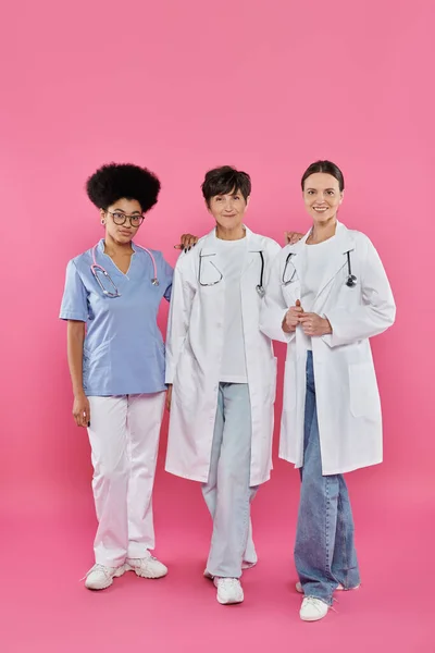 Oncólogos, tres doctores interraciales, concientización sobre el cáncer de mama, detección temprana, campaña - foto de stock