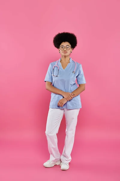 Consapevolezza del cancro al seno, medico afroamericano, oncologo femminile con stetoscopio, sfondo rosa — Foto stock