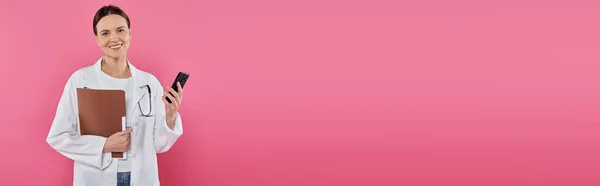 Consapevolezza del cancro al seno, medico di sesso femminile, oncologo felice con cartella utilizzando smartphone, banner — Foto stock