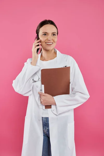 Осведомлённость о раке молочной железы, женщина-врач, счастливый онколог, говорящий на смартфоне, онлайн консультация — стоковое фото