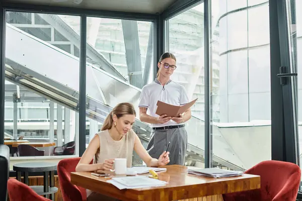 Young colleagues in business casual outfits working on documents with glass backdrop, coworking — Stock Photo