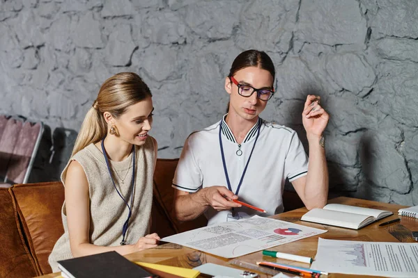 Two concentrated colleagues woman and man working on charts and paperwork, coworking concept — Stock Photo