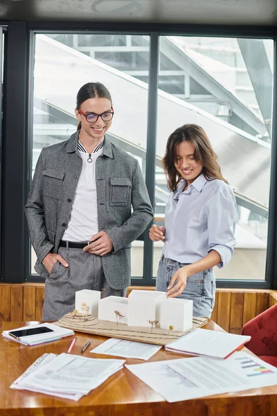 Creative team members in smart casual wear discussing scale model and paperwork, design bureau — Stock Photo
