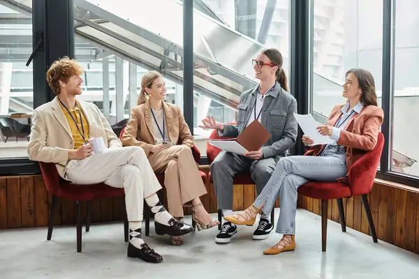 Equipo joven en traje casual de negocios sentado y discutiendo su trabajo con papeles, coworking — Stock Photo