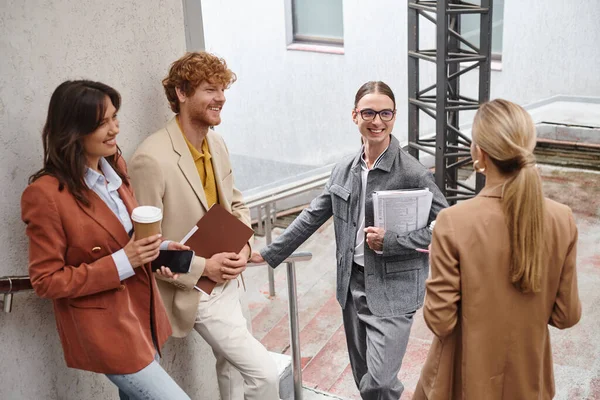 Four colleagues in smart attires enjoying lunch break outdoors smiling and chatting, coworking — Stock Photo