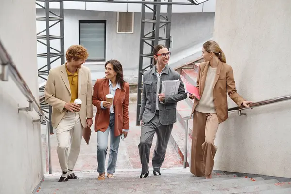 Felizes jovens membros da equipe andando lá em cima falando e sorrindo um para o outro, conceito de coworking — Fotografia de Stock