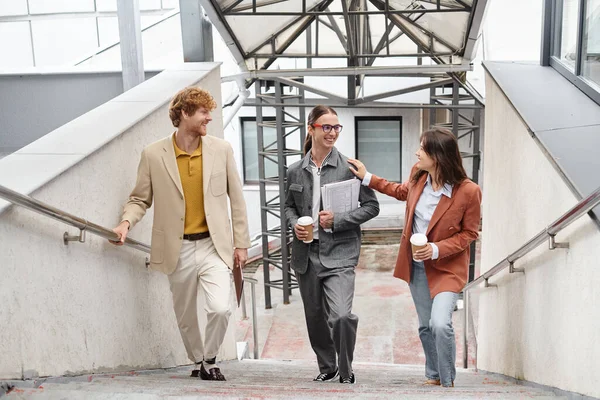 Trois jeunes collègues marchant à l'étage et souriant sincèrement, main sur épaule, concept de coworking — Photo de stock