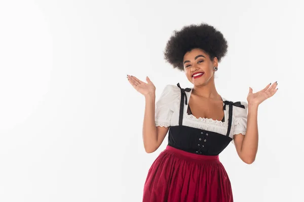 Happy african american bavarian waitress in traditional costume inviting to oktoberfest on white — Stock Photo