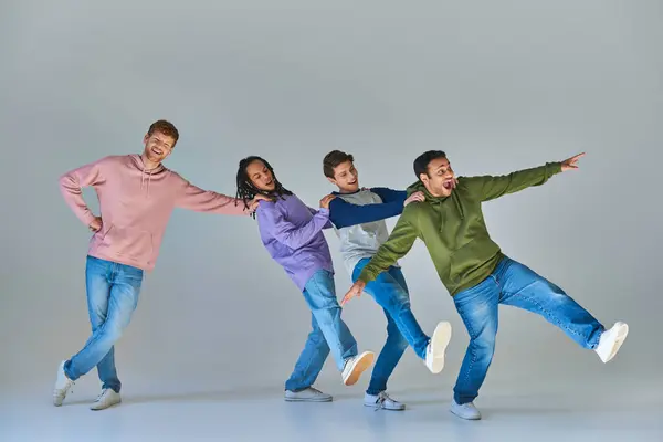 Cuatro jóvenes hombres alegres en ropa casual divertirse, las manos en los hombros, la diversidad cultural - foto de stock
