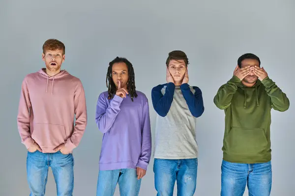 Four friends in casual bright attire standing and gesturing on grey background, cultural diversity — Stock Photo