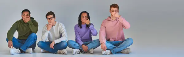 Vier junge Freunde sitzen mit gekreuzten Beinen und bedecken den Mund, kulturelle Vielfalt, Banner — Stockfoto