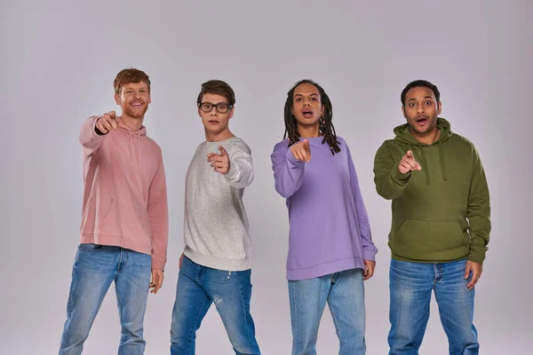 Young handsome men standing and pointing fingers at camera on grey background, cultural diversity — Stock Photo