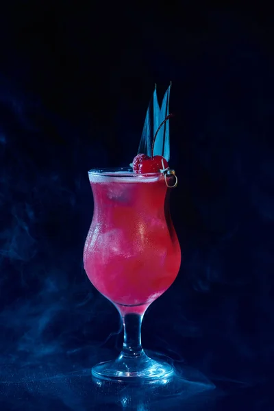 Exotic singapore sling cocktail with raspberry garnishing on black smokey backdrop, concept — Stock Photo