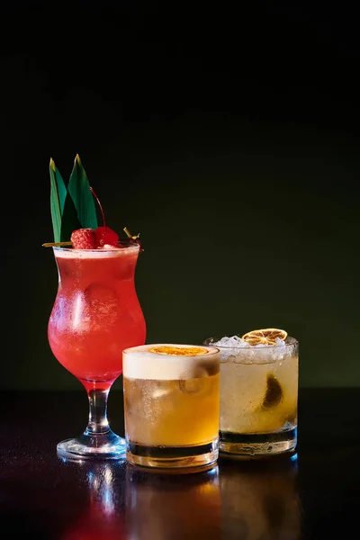 Tropical caipirinha and singapore sling, elegant whiskey sour on black backdrop, concept — Stock Photo