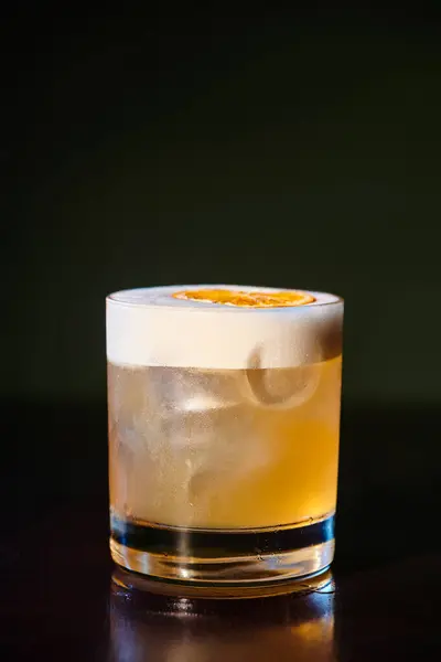 Abschreckend erfrischende Whiskey Sour mit köstlichem Schaumstoff auf schwarzem Hintergrund, Konzept — Stockfoto