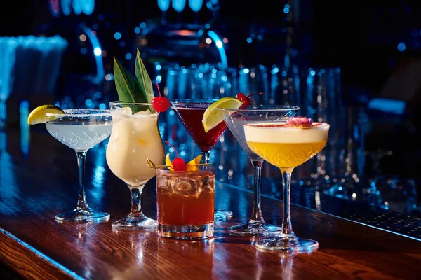 Sechs verschiedene aktuelle und elegante Cocktails mit Barkabinett im Hintergrund, Konzept — Stockfoto