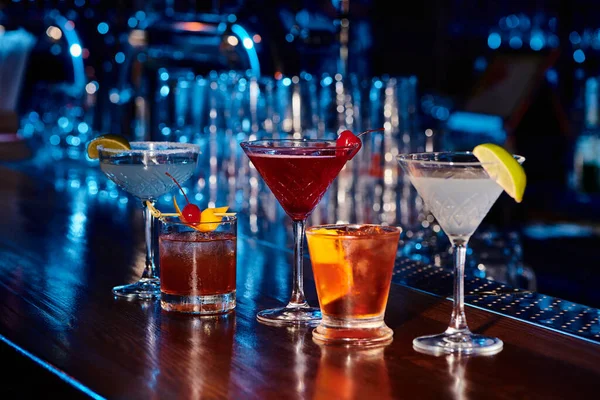 Cinco exóticos cócteles para calmar la sed en el mostrador del bar con bar en el fondo, concepto - foto de stock