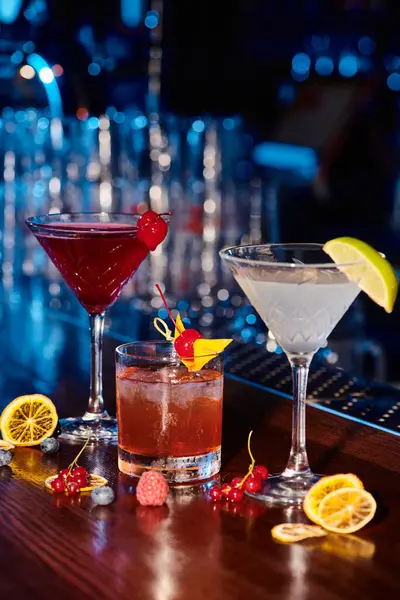 Блискучі витончені коктейлі з прикрасою на барній стійці зі свіжими ягодами, концепція — стокове фото