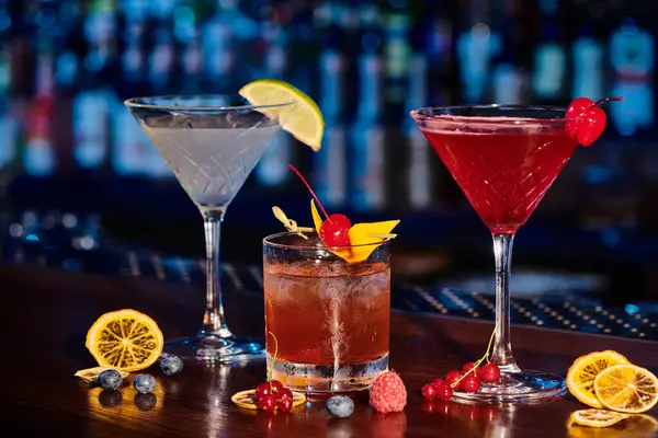 Durstlöschende Cocktails mit frischen Dekorationen auf Theke mit Barkulisse, Konzept — Stockfoto