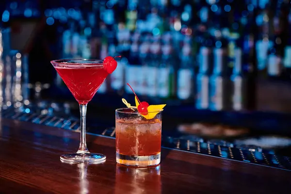 Exotische anspruchsvolle Cocktails mit Kirschen dekoriert mit Bar auf Hintergrund, Konzept — Stockfoto