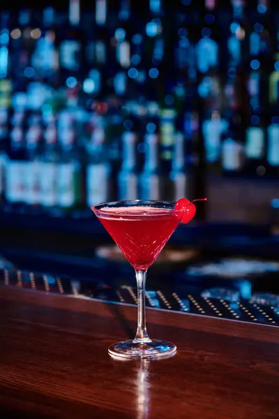 Eleganter kosmopolitischer Cocktail im Martini-Glas mit Kirsch an der Theke, Konzept — Stockfoto