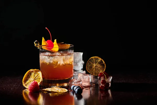 Durstlöschender Negroni garniert mit Cocktailkirsche auf schwarzem Hintergrund, Konzept — Stockfoto
