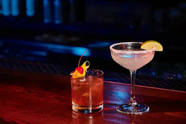Margarita esotica e gustosi negroni guarniti con ciliegia e lime sul bancone del bar, concept — Foto stock