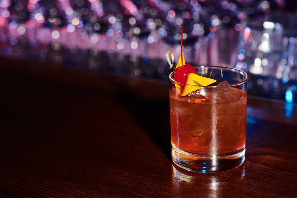 Элегантная жажда утоляющая негрони, украшенная коктейльной вишней на барной стойке, концепция — стоковое фото