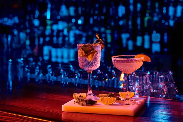 Verre sophistiqué de délicieux cocktails avec garnitures sur comptoir de bar, concept — Photo de stock