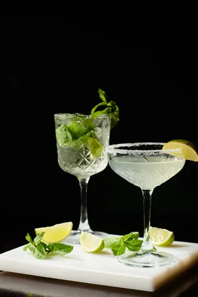 Delicious bohemian rhapsody and margarita with decorations on black backdrop, concept — Stock Photo