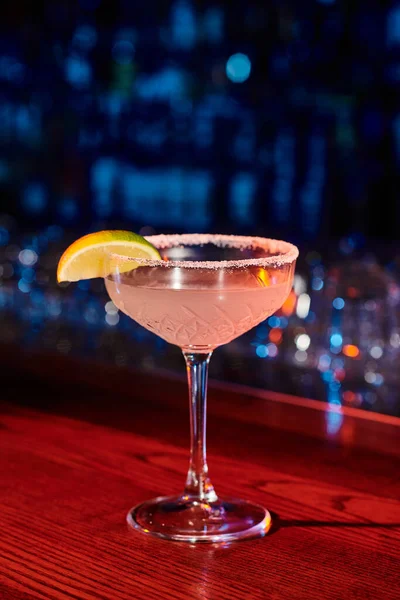 Durstlöschender eiskalter Margarita-Cocktail mit Limette mit Barhintergrund, Konzept — Stockfoto