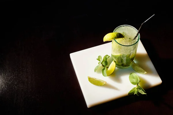 Top view bicchiere completo di cocktail mojito con cubetti di ghiaccio e menta su sfondo nero, concept — Foto stock