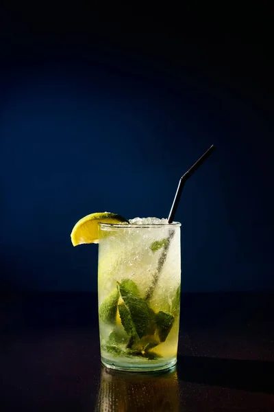 Durstlöschendes Glas Mojito garniert mit Minze und Limette auf dunklem Hintergrund, Konzept — Stockfoto