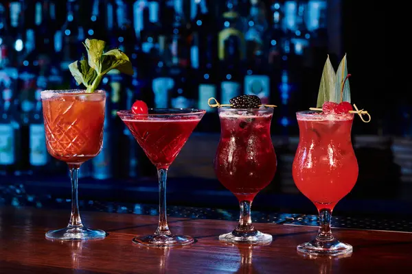 Freshening set of four cocktails with garnishments on counter with bar backdrop, concept — Stock Photo