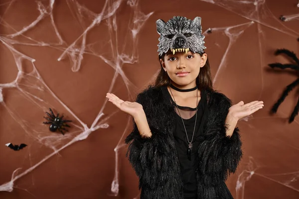 Nahaufnahme Preteen Girl zuckt mit den Schultern auf braunem Hintergrund mit Spinnweben und Spinnen, Halloween — Stockfoto